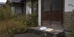 相続放棄後の空き家と手続き書類をイメージした古い日本家屋と封書の写真
