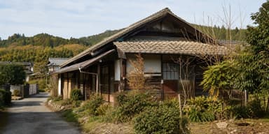 雪の残る田舎の集落に建つ古い空き家をイメージした写真