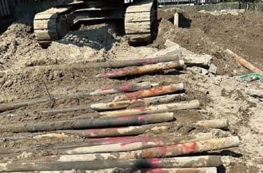 解体現場で地中から掘り出され、地面に並べられた多数の鋼管杭