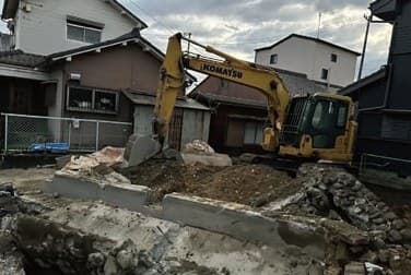 住宅地の解体現場で、重機の前に掘り出されたコンクリートの深基礎